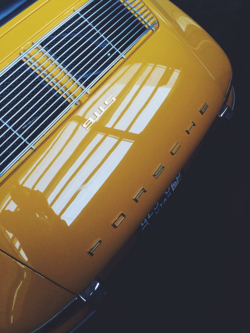 Detail van de motorklep van een gele Porsche 911